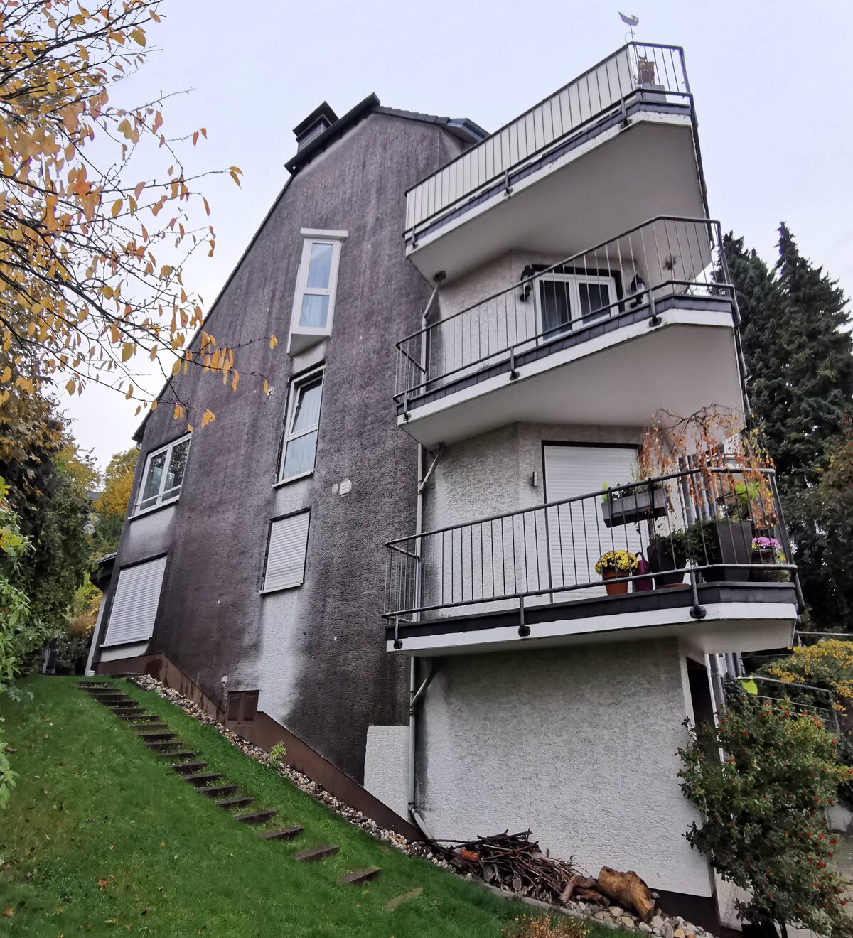 Vorher: Mehrfamilienhaus mit Balkonen, Putzfassade vor und nach Reinigung